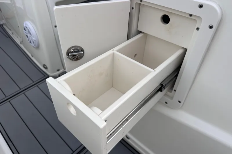 Slide: The Image of 2020 NauticStar 25 XS boat storage compartment with open drawer and lock. - 59