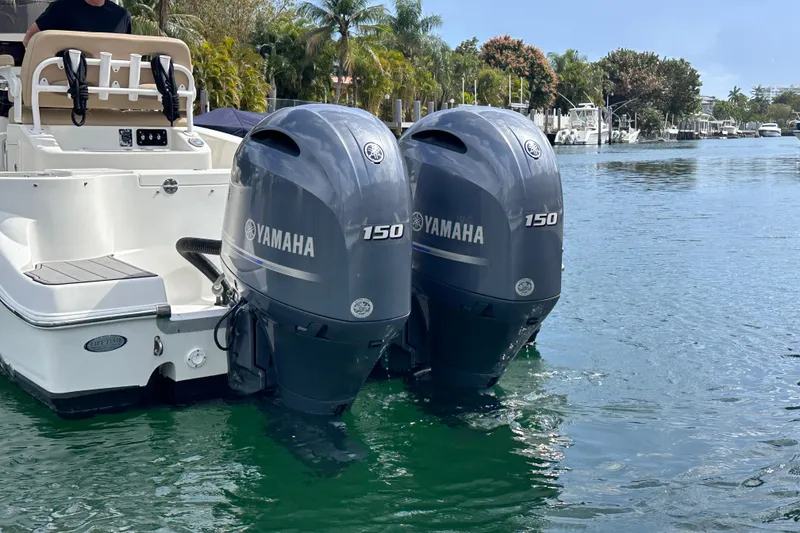 Slide: The Image of 2020 NauticStar 25 XS boat with twin Yamaha 150 outboard engines on a calm waterway. - 60