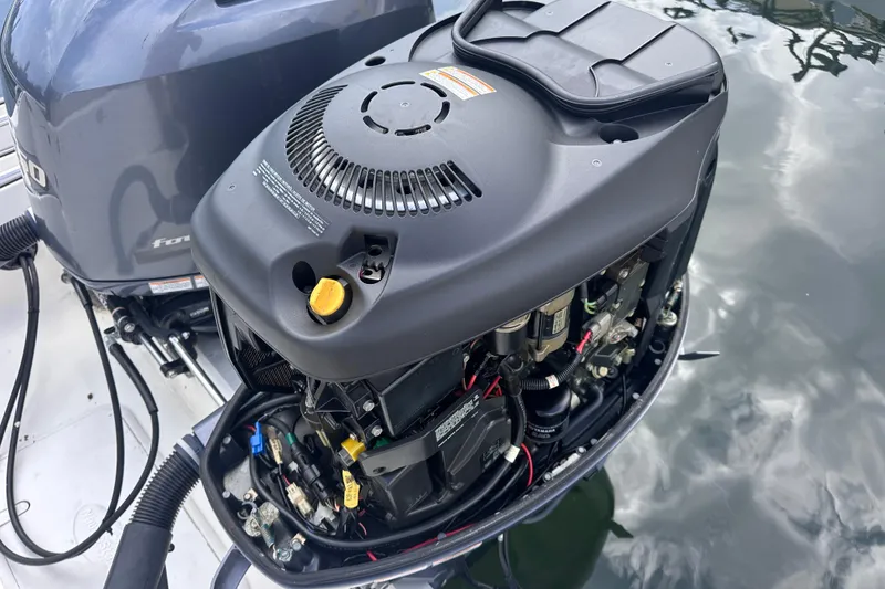 Slide: The Image of 2020 NauticStar 25 XS boat engine with open cover, showing internal components. - 64