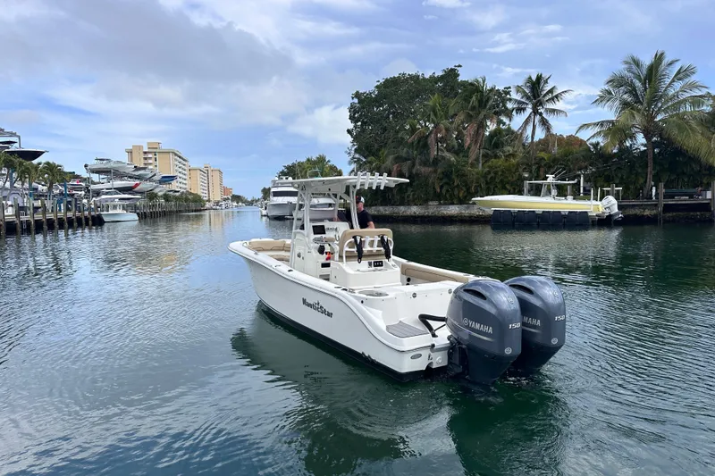 Slide: The Image of 2020 NauticStar 25 XS boat cruising on a scenic waterway with palm trees. - 7