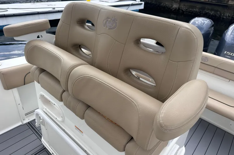 Slide: The Image of 2020 NauticStar 25 XS boat seat with beige upholstery and armrests. - 81