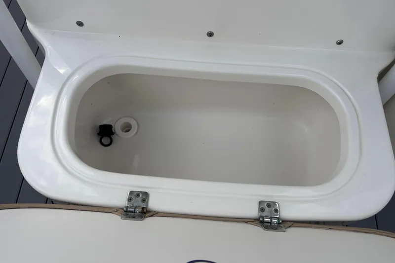 Slide: The Image of Open storage compartment on 2020 NauticStar 25 XS boat, featuring a white interior. - 83