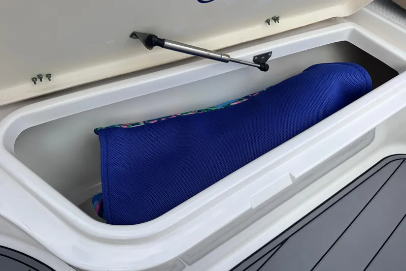 Slide: The Image of 2020 NauticStar 25 XS storage compartment with blue cushion inside. - 85