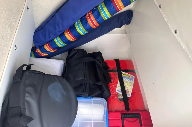 Slide: The Image of Storage compartment of 2020 NauticStar 25 XS boat with bags and safety equipment. - 87