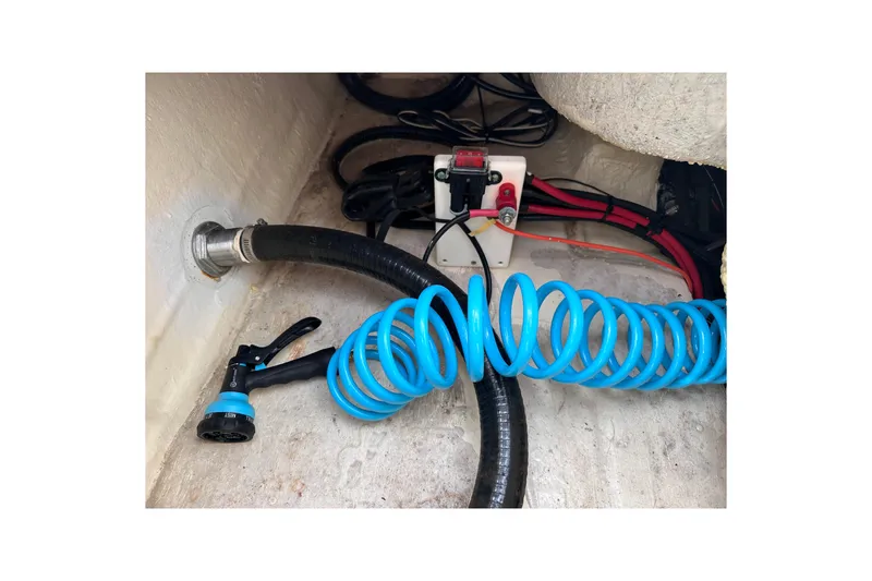 Slide: The Image of 2020 NauticStar 25 XS boat interior with coiled blue hose and wiring. - 90