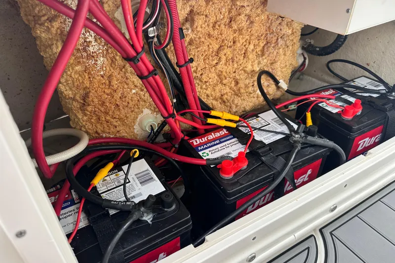 Slide: The Image of Batteries and wiring inside a 2020 NauticStar 25 XS boat compartment. - 91