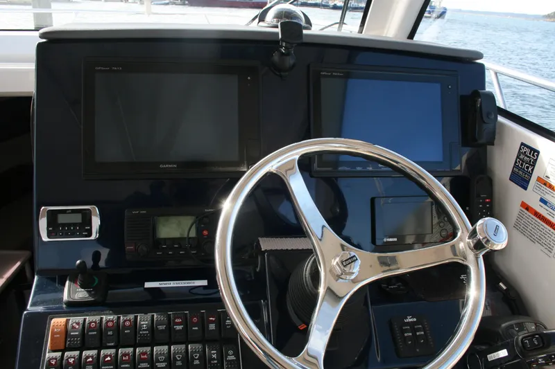 Slide: The Image of Helm of 2016 Pursuit OS 325 Offshore boat with navigation equipment and steering wheel. - 12