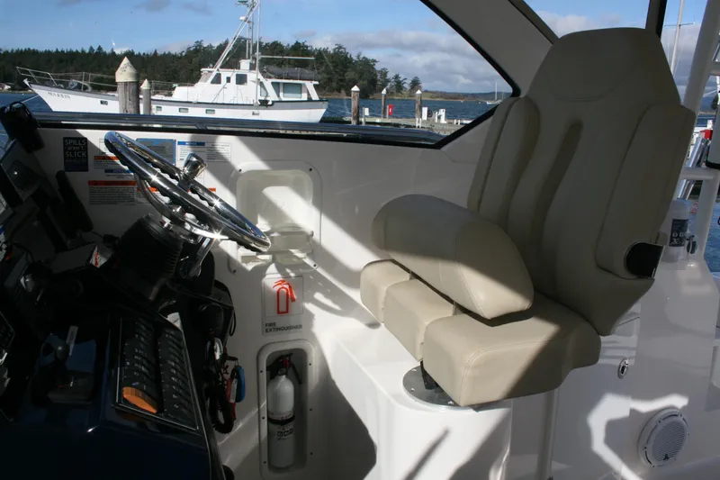 Slide: The Image of Interior of 2016 Pursuit OS 325 Offshore boat with steering wheel and captain's chair. - 13