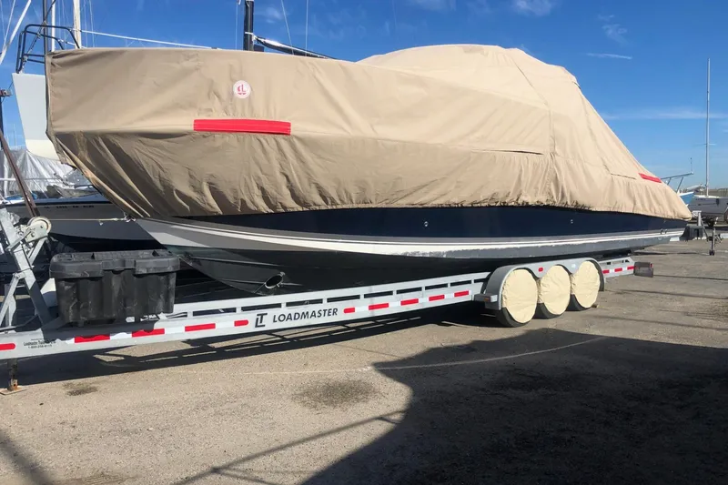 Slide: The Image of 2016 Pursuit OS 325 Offshore boat covered on a Loadmaster trailer. - 22