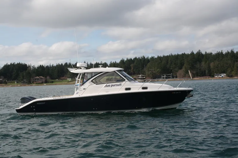 Slide: The Image of 2016 Pursuit OS 325 Offshore boat on water, forested shoreline in background. - 4