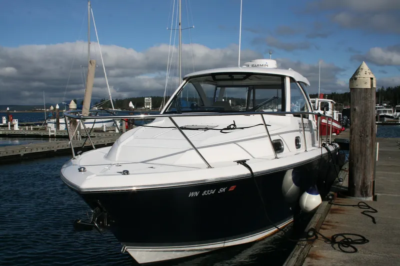 Slide: The Image of 2016 Pursuit OS 325 Offshore boat docked at marina under cloudy sky. - 6
