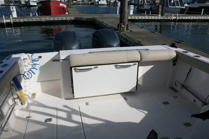 Slide: The Image of 2016 Pursuit OS 325 Offshore boat interior with seating and dock view. - 9