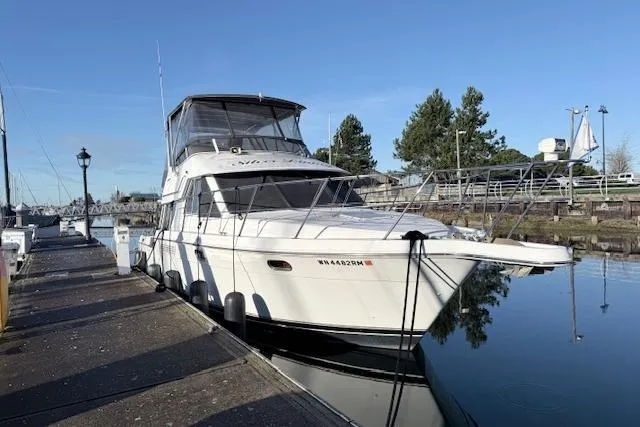 The Image of 1998 Carver 370 Voyager yacht docked at a marina on a clear day. - 0