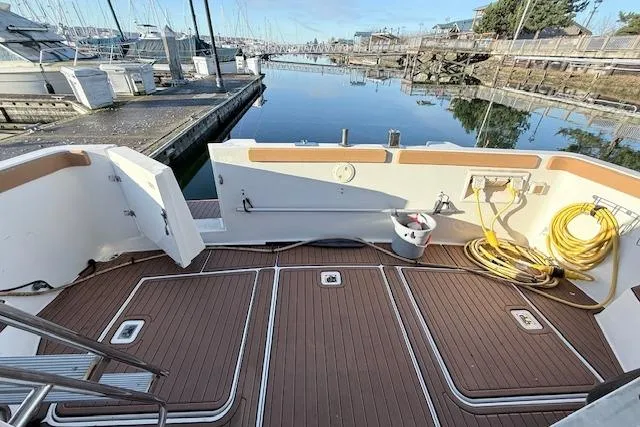 Slide: The Image of 1998 Carver 370 Voyager boat deck at marina, featuring clean wood finish and dockside view. - 10