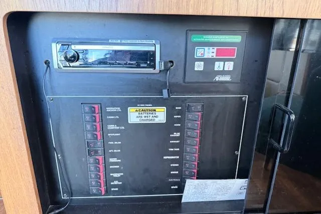 Slide: The Image of Control panel of a 1998 Carver 370 Voyager boat with various switches and a stereo system. - 11