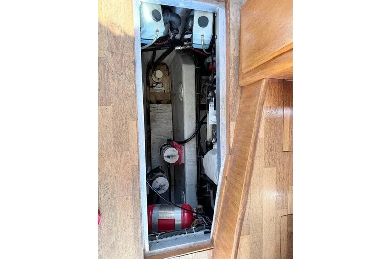 Slide: The Image of Engine compartment of 1998 Carver 370 Voyager with visible components and wooden flooring. - 15