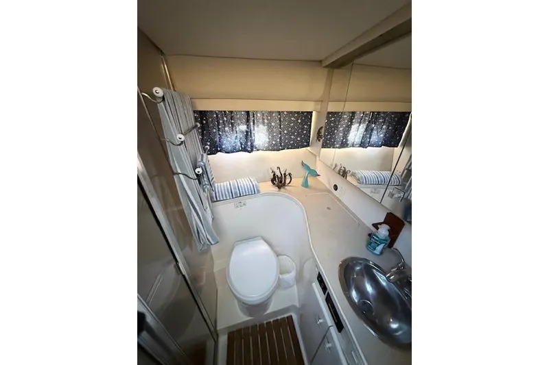 Slide: The Image of 1998 Carver 370 Voyager bathroom with sink, toilet, and nautical decor. - 3