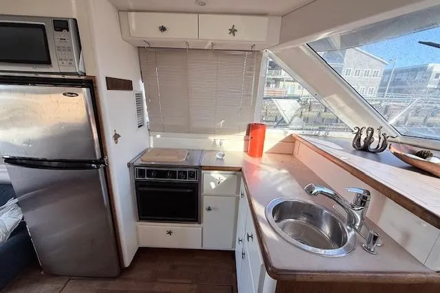 Slide: The Image of 1998 Carver 370 Voyager yacht kitchen with stainless steel appliances and wooden cabinetry. - 7