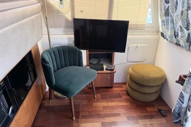 Slide: The Image of Interior of 1998 Carver 370 Voyager with TV, green chair, and round ottoman. - 9