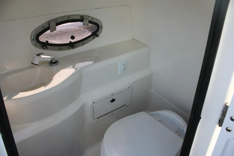 Slide: The Image of 2018 NauticStar 243DC Sport Deck boat interior with compact bathroom amenities. - 13