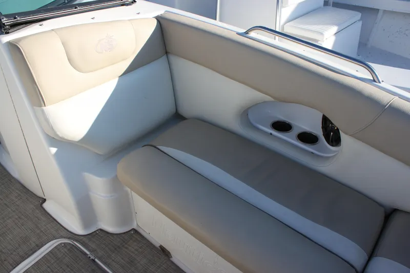 Slide: The Image of 2018 NauticStar 243DC Sport Deck interior seating with cup holders and beige upholstery. - 7