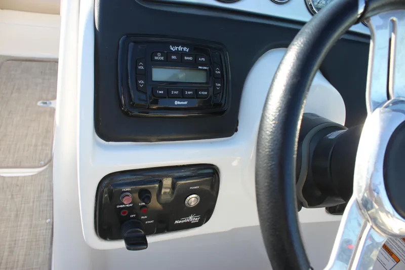 Slide: The Image of 2018 NauticStar 243DC Sport Deck dashboard with steering wheel and control panel. - 17