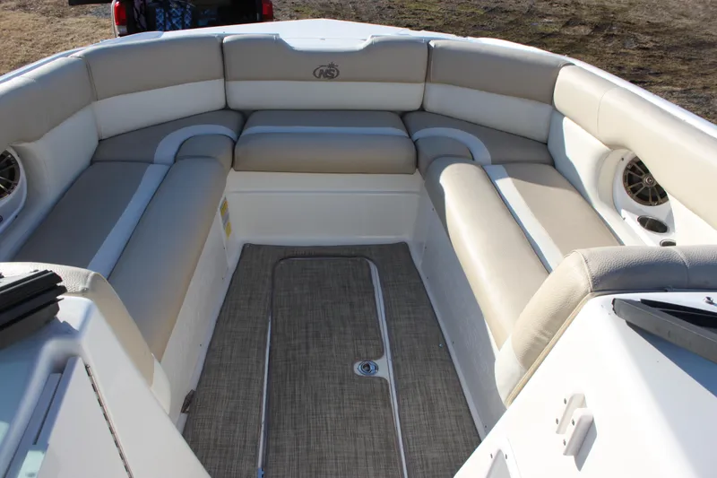 Slide: The Image of 2018 NauticStar 243DC Sport Deck boat interior with beige seating and carpeted floor. - 5