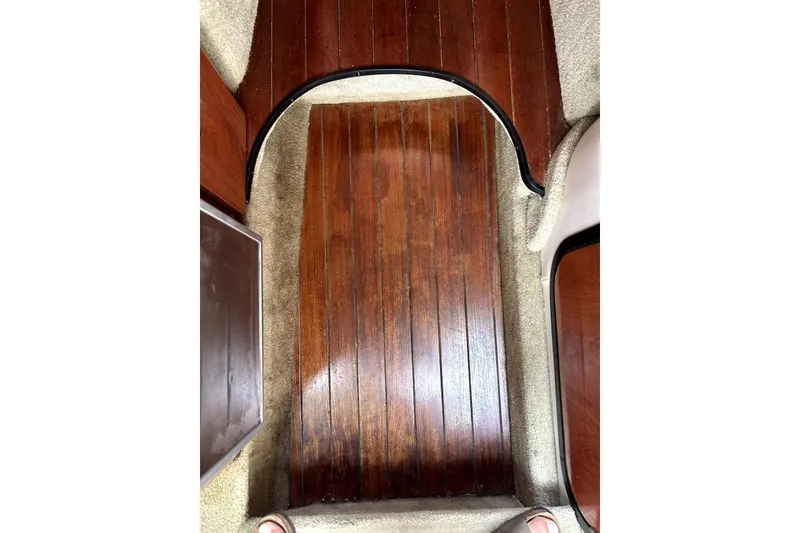 Slide: The Image of 2012 Crownline 260 CR cabin interior with beige seating and star-patterned cushions. - 11