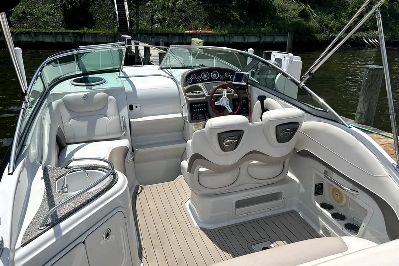 Slide: The Image of 2012 Crownline 260 CR boat docked on a calm lake under a clear sky. - 2