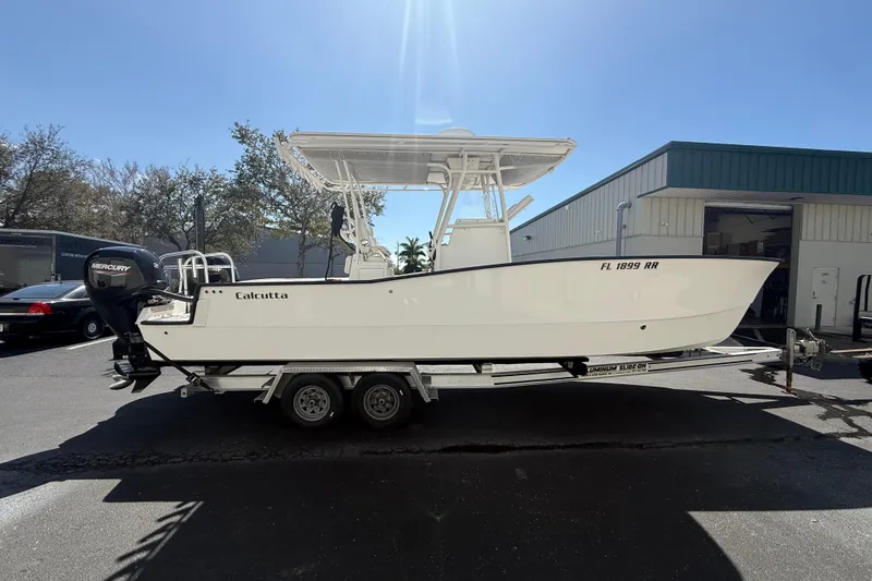 Slide: The Image of 2019 Calcutta 263 boat on trailer, parked outdoors under clear sky. - 20