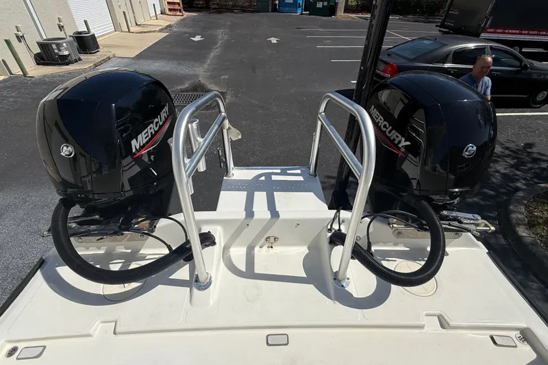 Slide: The Image of Twin Mercury outboard engines on a 2019 Calcutta 263 boat in a parking lot. - 24