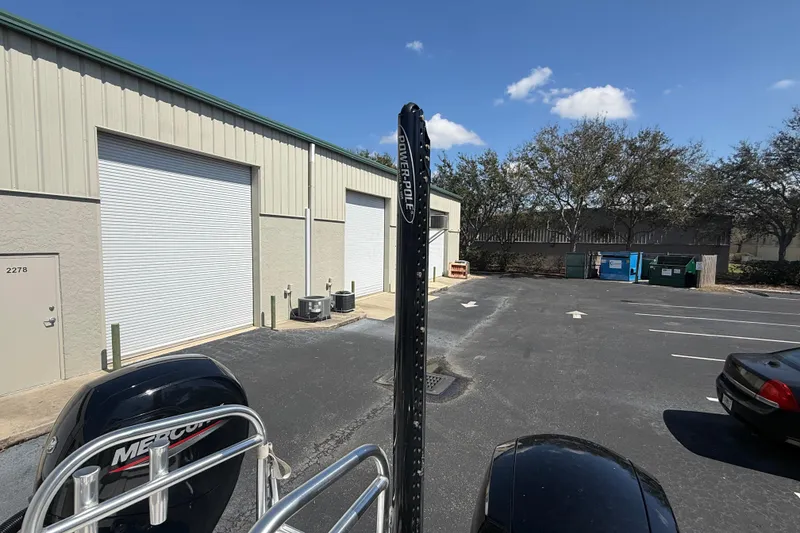 Slide: The Image of Outdoor view of a Calcutta 263 boat near storage units, featuring a Power-Pole and Mercury engine. - 25
