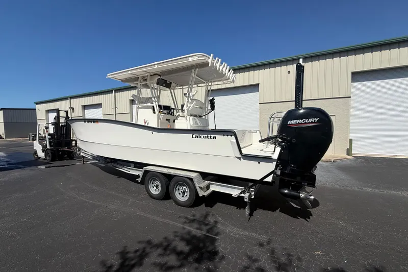Slide: The Image of 2019 Calcutta 263 boat on trailer with Mercury outboard, parked near industrial building. - 3