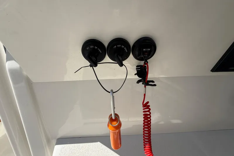 Slide: The Image of Control panel of a 2019 Calcutta 263 boat with ignition switches and safety lanyard. - 33