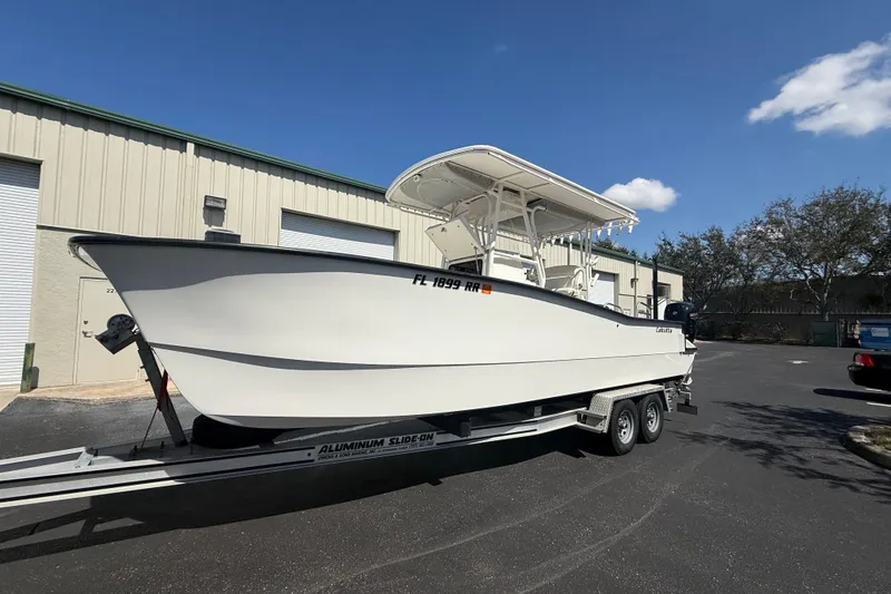 Slide: The Image of 2019 Calcutta 263 boat on trailer, parked outside a warehouse under clear blue sky. - 4