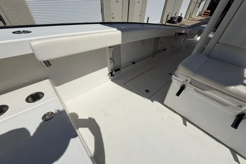 Slide: The Image of Interior of a 2019 Calcutta 263 boat, featuring white seating and storage compartments. - 52