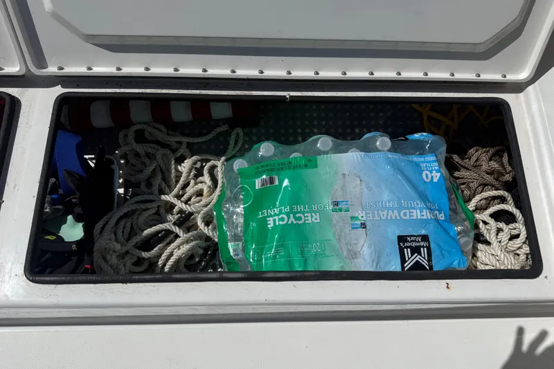 Slide: The Image of Storage compartment with ropes and bottled water in a 2019 Calcutta 263 boat. - 63