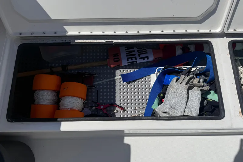 Slide: The Image of Storage compartment in a 2019 Calcutta 263 boat with ropes, gloves, and safety gear. - 64