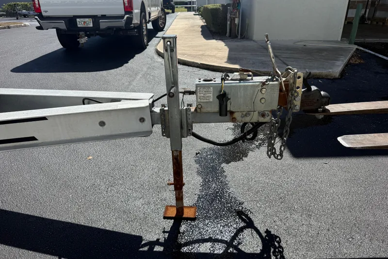Slide: The Image of Trailer hitch of a 2019 Calcutta 263 on asphalt, with a parked truck nearby. - 71