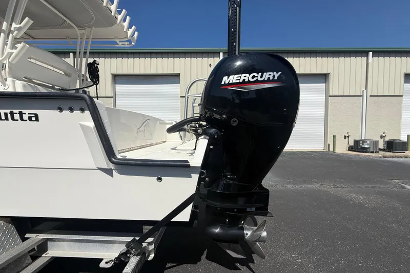 Slide: The Image of 2019 Calcutta 263 boat with Mercury outboard motor in a sunny industrial setting. - 9