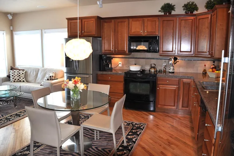 Slide: The Image of Modern kitchen with wooden cabinets, glass dining table, and cozy living area. - 20