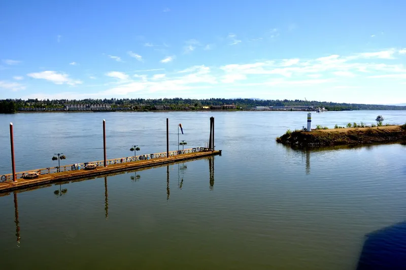 Slide: The Image of Calm river view with dock and lighthouse, featuring Steelhead Marine Boat House, 2004. - 27