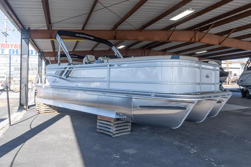 The Image of 2026 SunCatcher Select 322RC pontoon boat displayed in a covered marina area. - 0