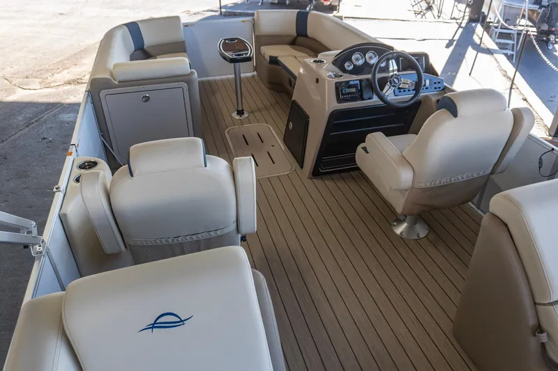 Slide: The Image of 2026 SunCatcher Select 322RC boat interior with beige seating and modern dashboard. - 14