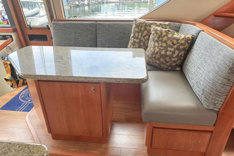 Slide: The Image of 2004 West Bay Sonship yacht interior with cushioned seating and granite table. - 11