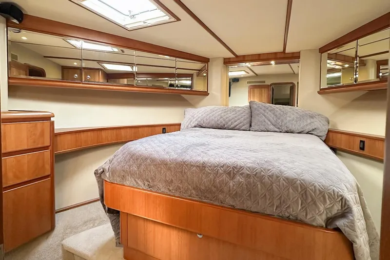 Slide: The Image of Luxurious 2004 West Bay Sonship yacht bedroom with elegant wood finishes and cozy bedding. - 18