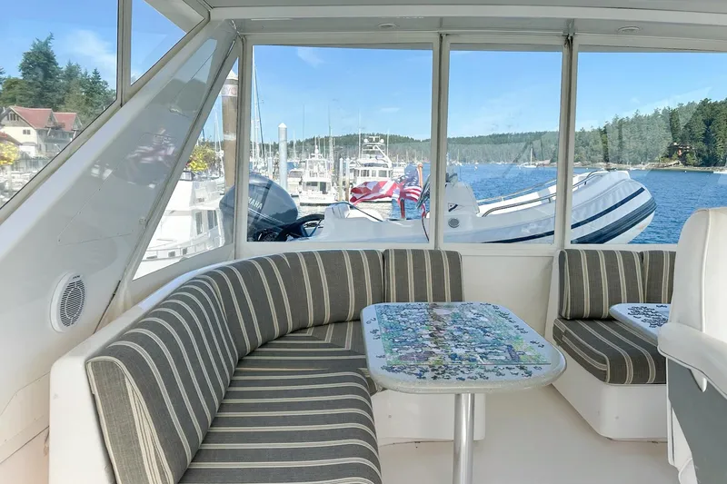Slide: The Image of 2004 West Bay Sonship yacht interior with striped seating and scenic marina view. - 20