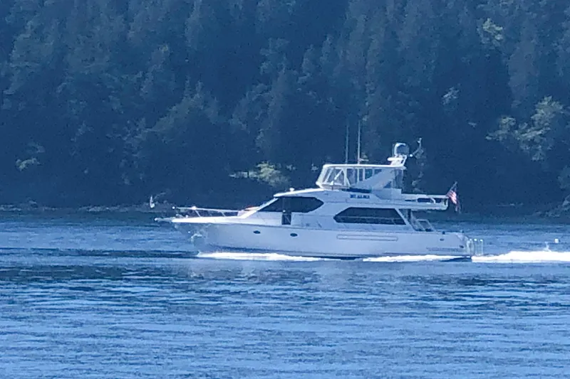 Slide: The Image of 2004 West Bay Sonship yacht cruising on a serene lake with forested backdrop. - 3