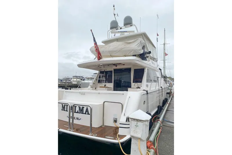 Slide: The Image of 2004 West Bay Sonship yacht docked at marina, rear view with American flag. - 4