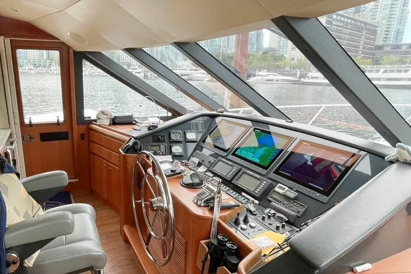 Slide: The Image of 2004 West Bay Sonship yacht helm with navigation screens and steering wheel, docked in marina. - 7